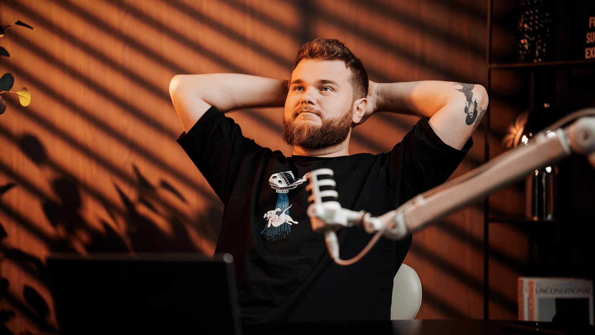 Szymon patrzy w telefon, uniesiona brew / lekki niesmak